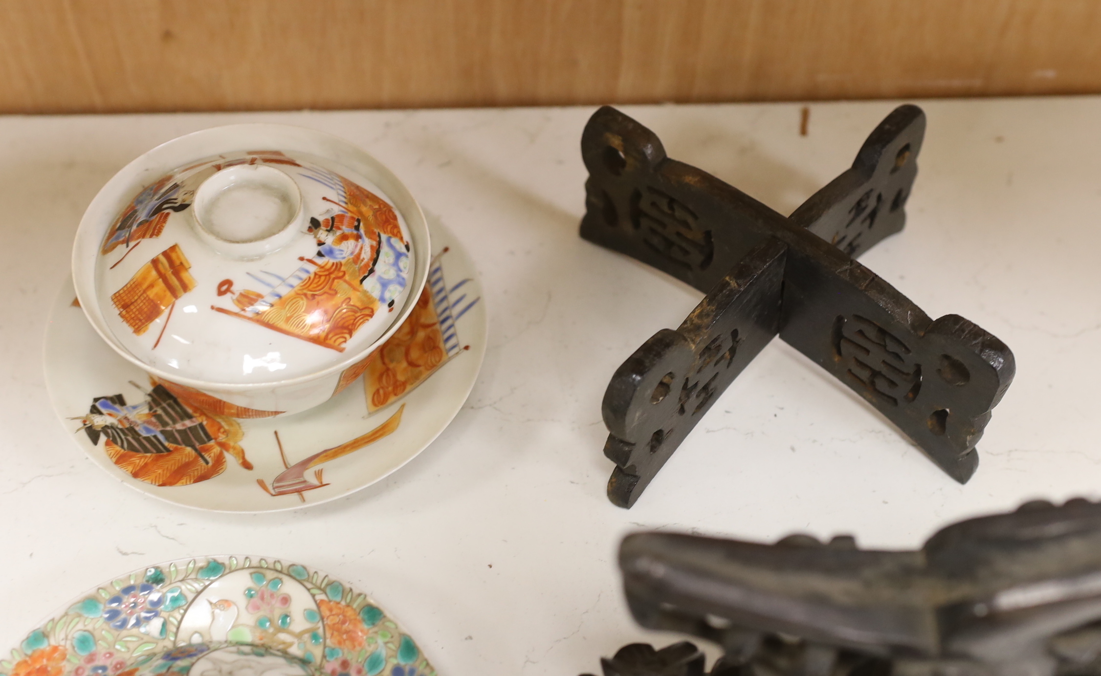 Two Japanese tea bowls one with cover and saucer, a saucer and cover, two Chinese soapstone carvings and four stands